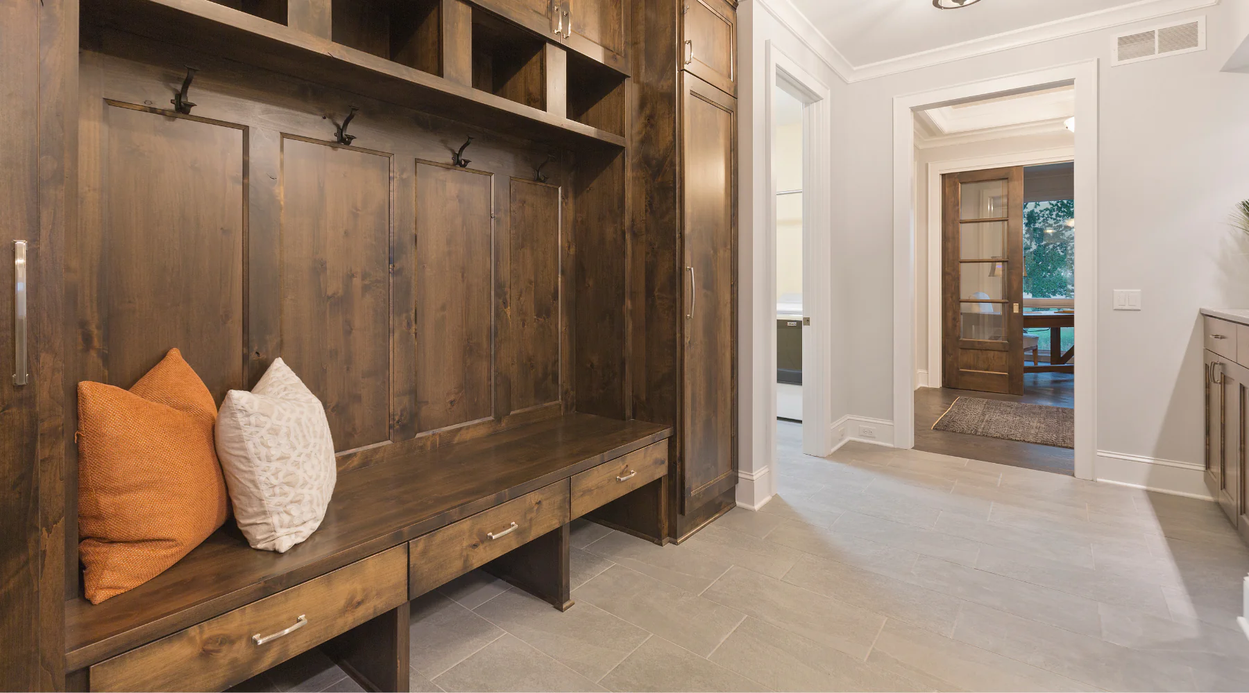 Light gray tile flooring in a spacious mudroom with built-in storage